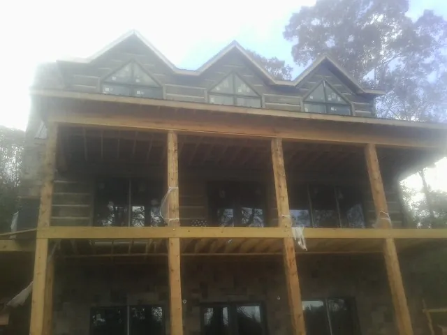 Dormers and porch framing on a large log home under construction — Roof Coating work by our crew in Mooresville