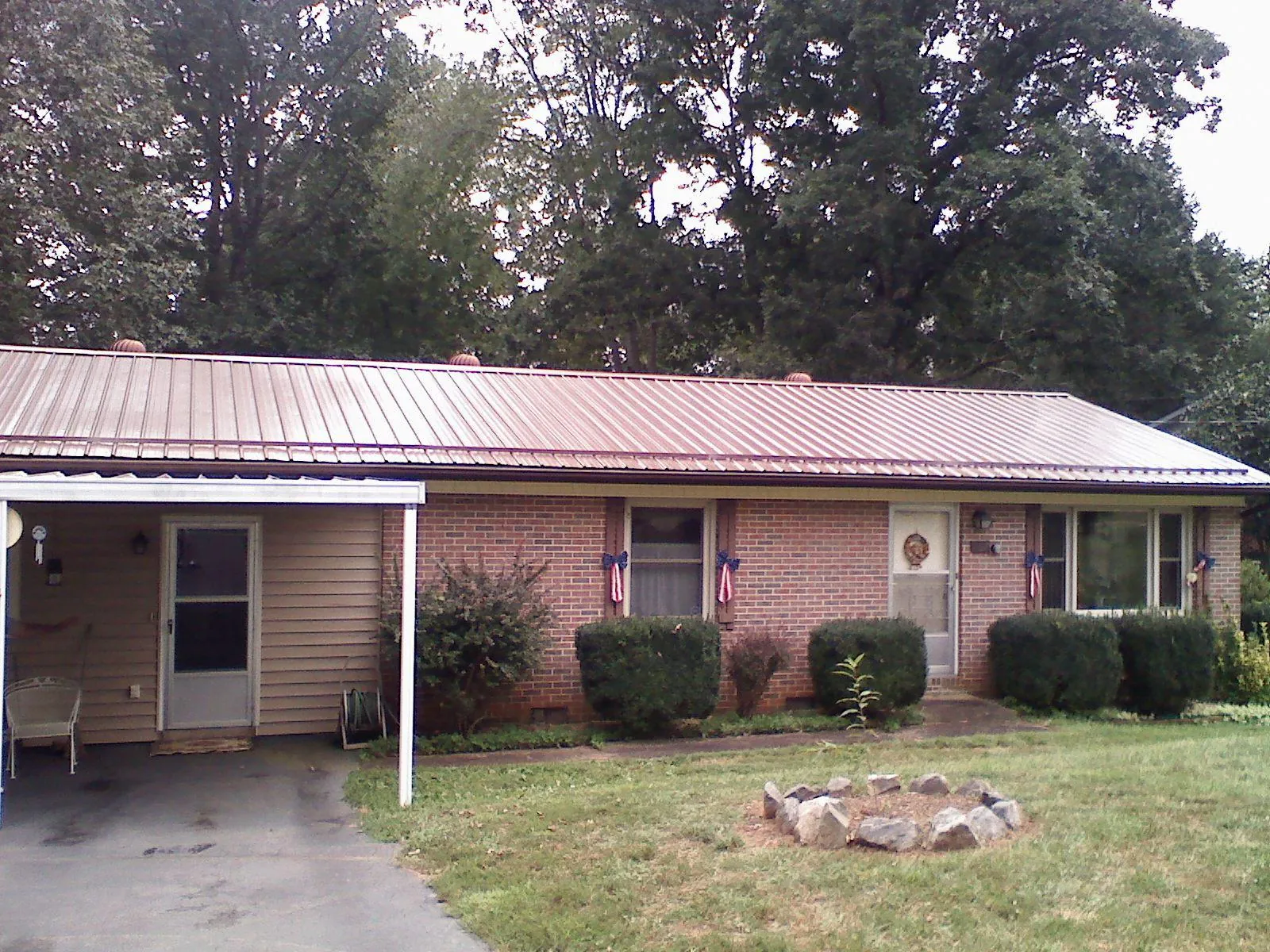 Bronze metal roof and carport on a brick ranch home — Roof Repair work by our crew in Mooresville